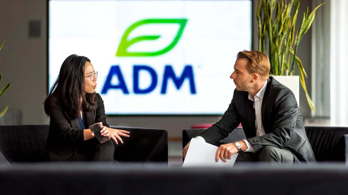 Two people meeting in the lobby of the ADM Heidelberg headquarters
