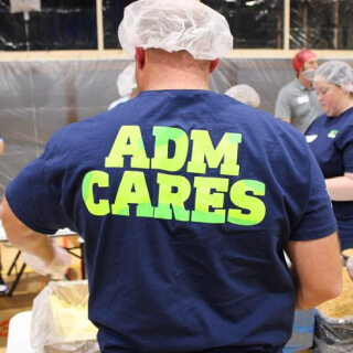 The back of a person wearing an ADM CARES t-shirt