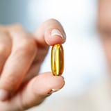 A hand holding a pill