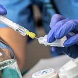 A person holding a syringe and needle