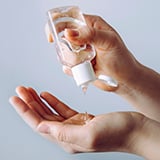 A person pouring hand sanitizer onto their hands