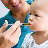 A baby being given medicine with a syringe