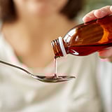 A person pouring liquid into a spoon