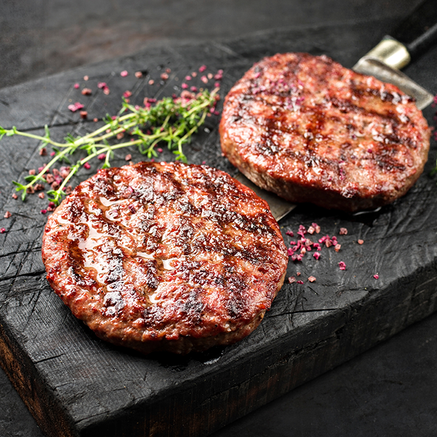 Two Burger Patties on a black table