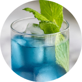 A glass of a bright blue beverage with an herb garnish