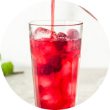 A glass of red iced hibiscus tea made with a naturally derived color solution