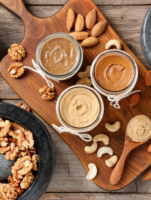 An overhead view of nut spreads on a serving board