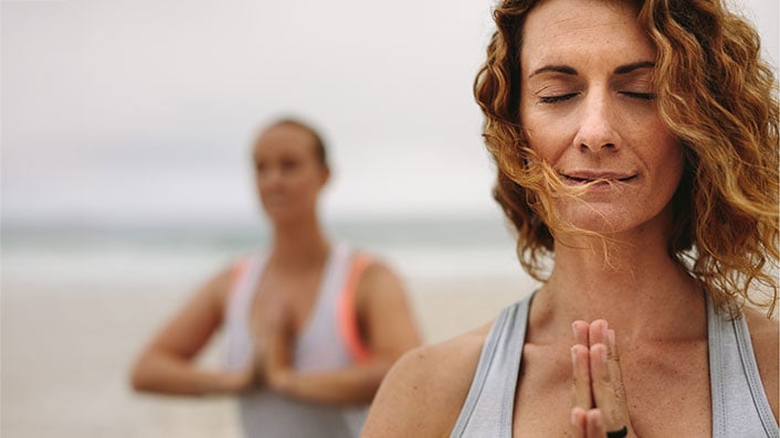 Closeup of a person in a meditation pose on a beach