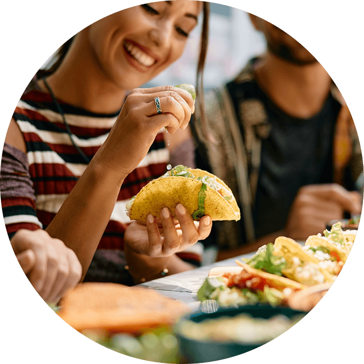 A person squeezing a lime over a taco