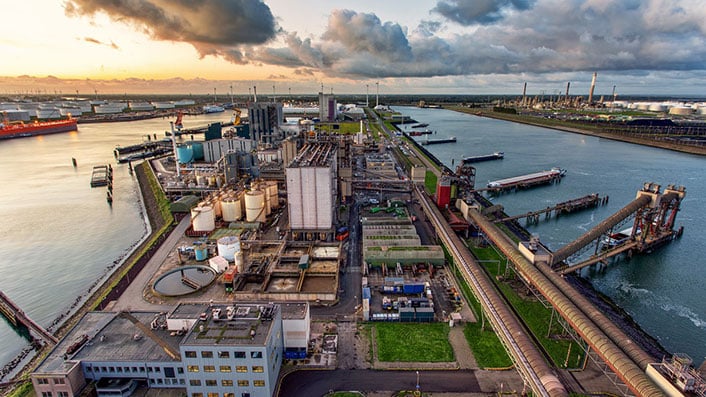 A large industrial area with water and buildings 