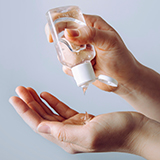 A person pouring hand sanitizer onto their hands