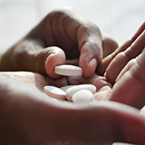 A person holding white pills