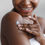 A person applying cream on her arm