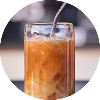 A glass of iced coffee with a straw