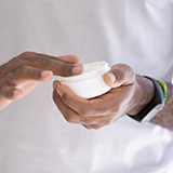 A person holding a jar of cream