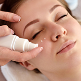 A close-up of a person as lotion is being applied to their face