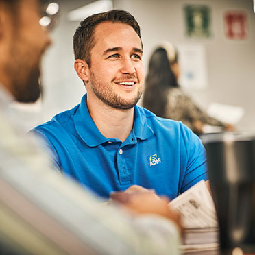 A man wearing a blue ADM-branded shirt