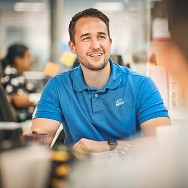 A smiling person in a blue ADM shirt